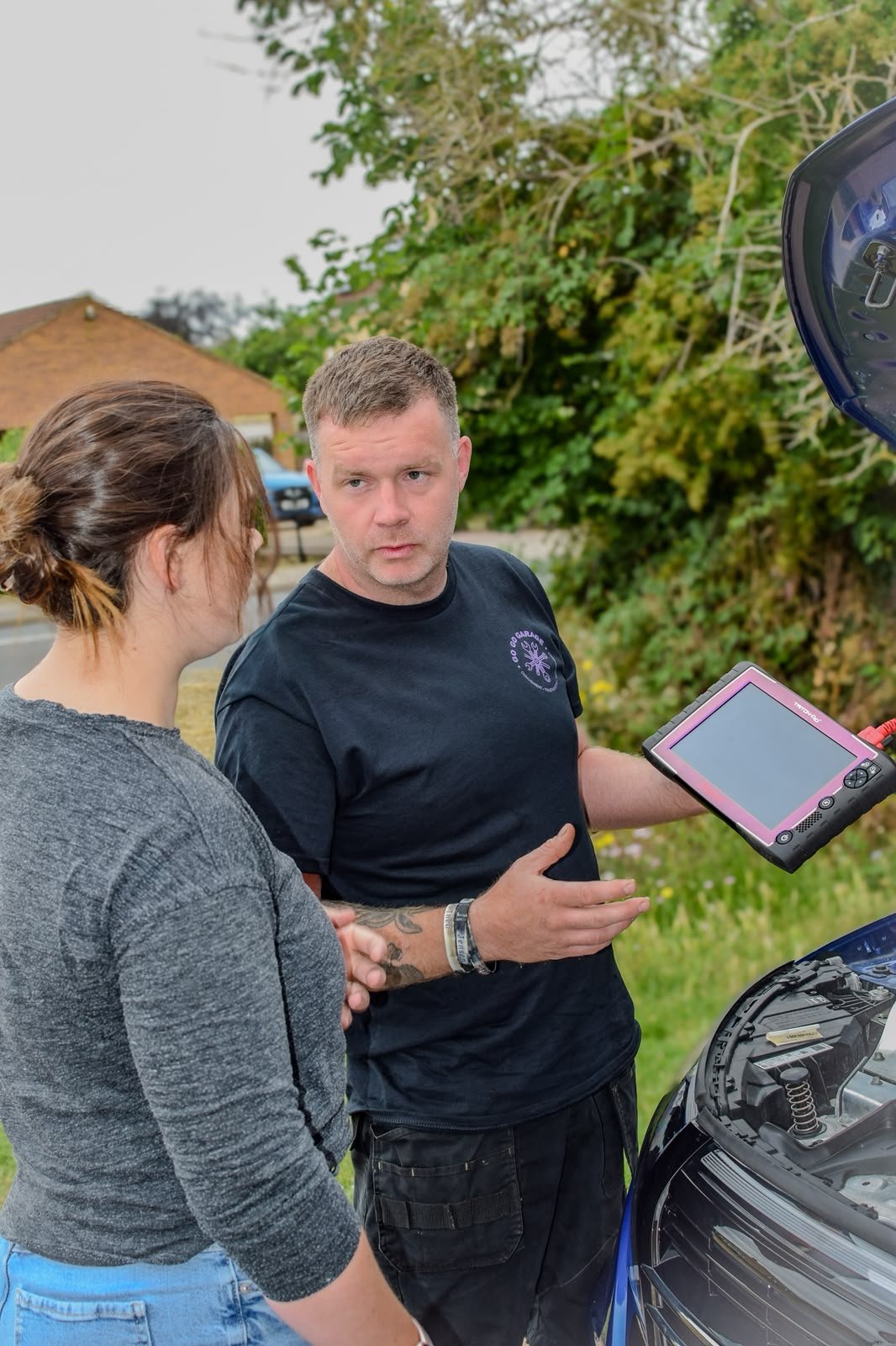 Tom talking a customer through her car's diagnostic results at the roadside